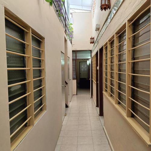 a corridor of a hospital with windows and a hallway at Kota Lodge Guest House in Melaka