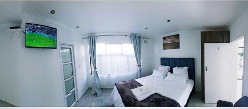 een slaapkamer met een wit bed en een raam bij Blue Nile Guest in Kaapstad