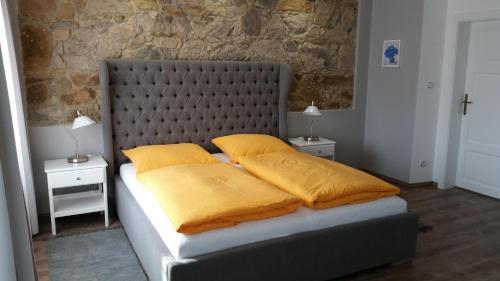 a bedroom with a large bed with yellow pillows at Penzion Valkoun-Lilienfeld in Karlovy Vary