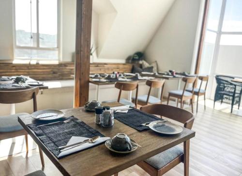 a dining room with tables and chairs with dishes on them at Swakopmund Luxury Suites in Swakopmund