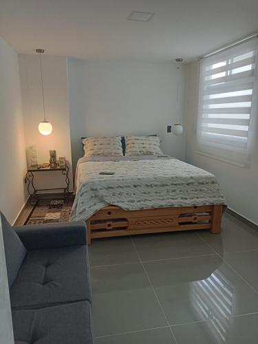 a bedroom with a large bed and a chair at nuevo amanecer in Bello