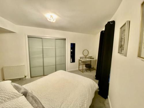 a white bedroom with a bed and a desk at Casa Kerr @ The Broch in Perth