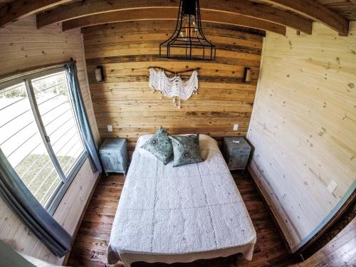 1 dormitorio en una cabaña de madera con 1 cama. en Aurora, en Aguas Dulces
