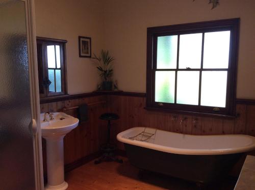 a bathroom with a bath tub and a sink at Butterfly Farm Bed and Breakfast Nirranda in Nirranda