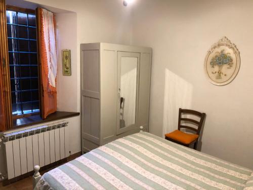 um quarto com uma cama, uma cadeira e uma janela em VACANZE A SESTOLA em Sestola