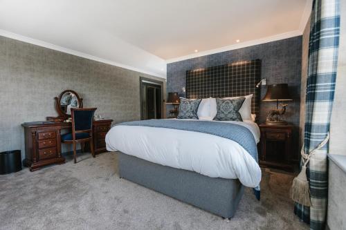 a bedroom with a bed and a desk and a mirror at Maryculter House in Maryculter