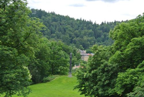 a statue in the middle of a field with trees at Penzion Valkoun-Lilienfeld in Karlovy Vary