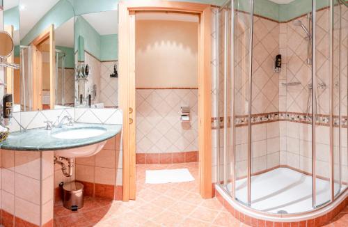 ein Bad mit einem Waschbecken und einer Dusche in der Unterkunft Hotel Reipertingerhof in Bruneck
