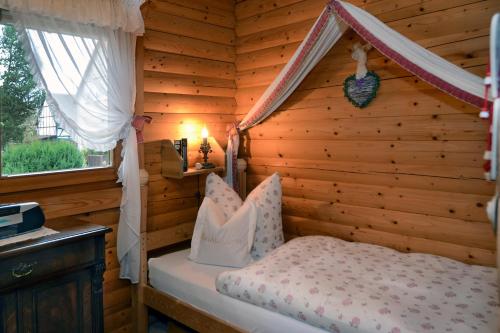 um quarto com uma cama num chalé de madeira em Apartments Am Kupferberg em Walkenried