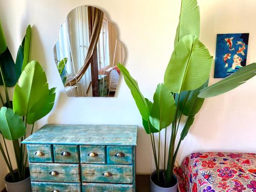 a room with plants and a blue dresser and a mirror at Lovely cosy art flat in Budapest
