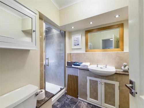 een badkamer met een wastafel en een douche bij Two Bed First Floor Apartment in Village location in Grantham