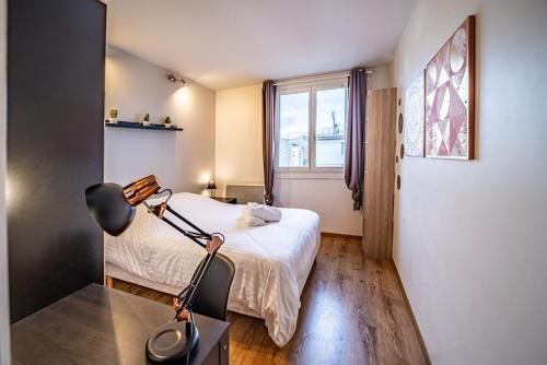 une chambre avec un lit et un bureau avec une lampe dans l'établissement 41 Vallier, à Grenoble