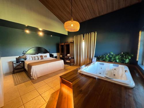 1 dormitorio con cama y bañera en Tenondé Park Hotel, en São Miguel das Missões
