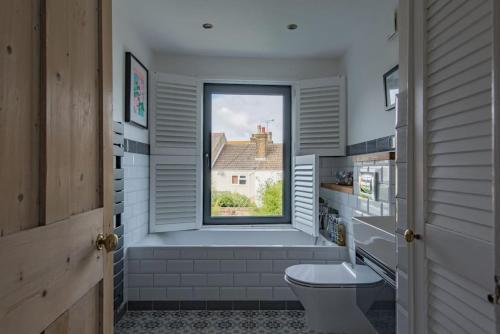 a bathroom with a toilet and a window at Rosewood in Walmer