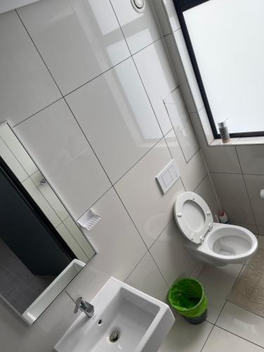 een witte badkamer met een toilet en een wastafel bij UNIT 26 @ 77 on Independence in Windhoek