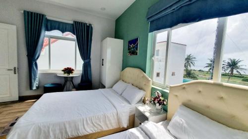 a bedroom with two beds and a large window at Khách Sạn Lý Sơn Phú Sỹ in Ly Son