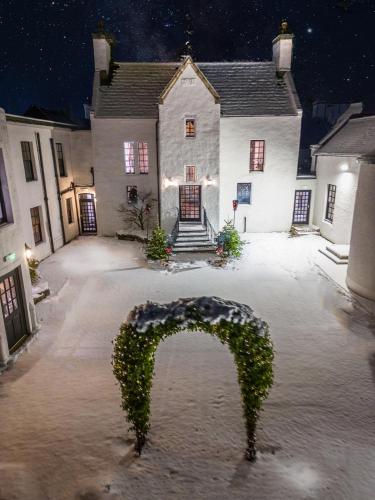an arch in the courtyard of a house at night at Maryculter House in Maryculter