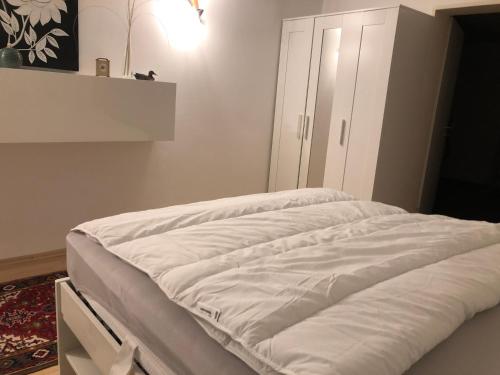 a bed with white sheets on it in a room at Ferienwohnung Nationalpark Eifel Nideggen Sauna in Nideggen