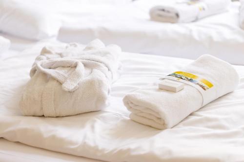 a pile of towels and a bottle of medicine on a bed at B&B Landgoed De Grote Beek in Eindhoven