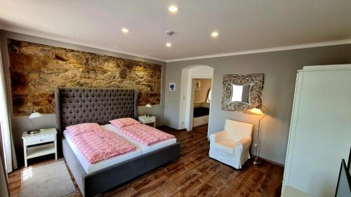 a bedroom with a bed and a stone wall at Penzion Valkoun-Lilienfeld in Karlovy Vary
