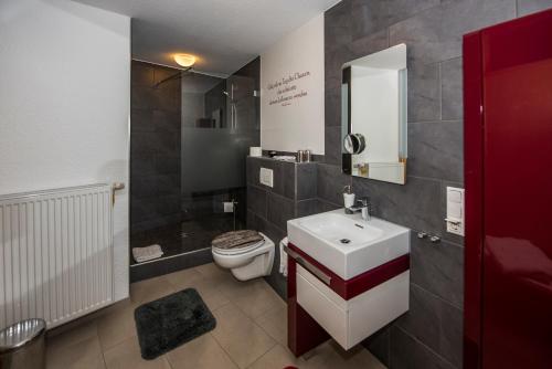a bathroom with a white sink and a toilet at Gästehaus Schmitt in Appenheim