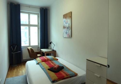 ウィーンにあるCasa Nostra - Ruhig & zentral wohnen am Augartenのベッドルーム1室(ドレッサー付きのベッド1台、窓付)