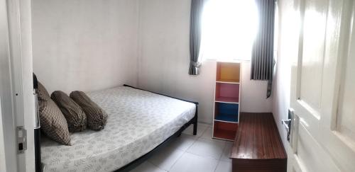 a small bedroom with a bed and a window at Hasna Home Stay in Wonosobo