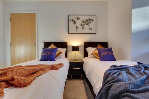 a bedroom with two beds with blue pillows at Home Away From Home - Contractors & Leisure in Sheffield