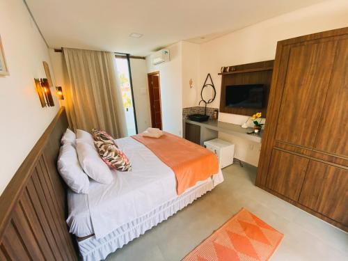 Dormitorio pequeño con cama y TV en Pousada Raroguis - Praia de Guaratiba en Prado