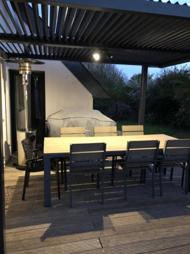 a wooden table and chairs on a patio at Les Bleuets - Erdivines in Erdeven