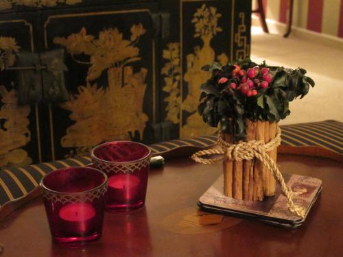 a table with two red candles and a vase with flowers at Lütt Wieck App Nr 12 in Wieck