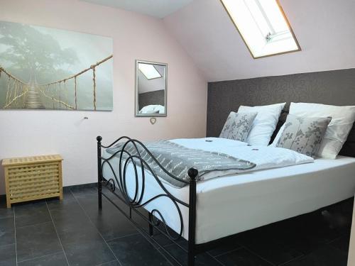 Schlafzimmer mit einem großen Bett und einem Dachfenster in der Unterkunft Ferienwohnungen Riedel in Pegnitz