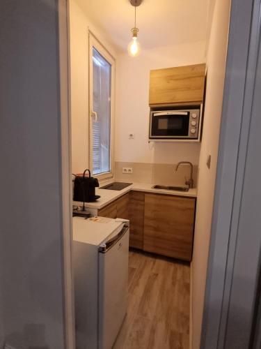 a small kitchen with a refrigerator and a microwave at Appartement Nice Centre Medecin in Nice