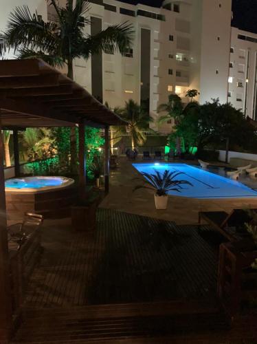 a large swimming pool at night in a city at Hotel Joao de Barro in Itajaí