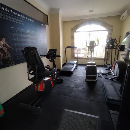 a gym with cardio equipment and a large window at Hotel Joao de Barro in Itajaí