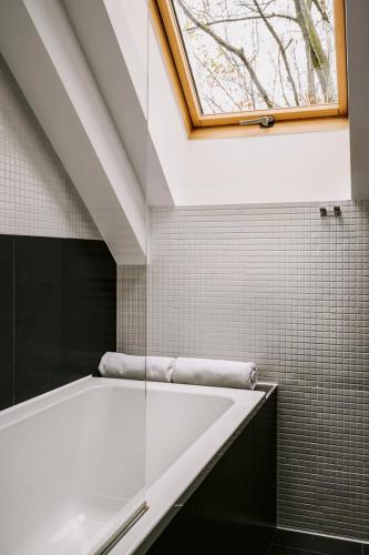 a bathroom with a window and a bath tub at Poziom 511 Jura Wellness Hotel & Spa in Ogrodzieniec