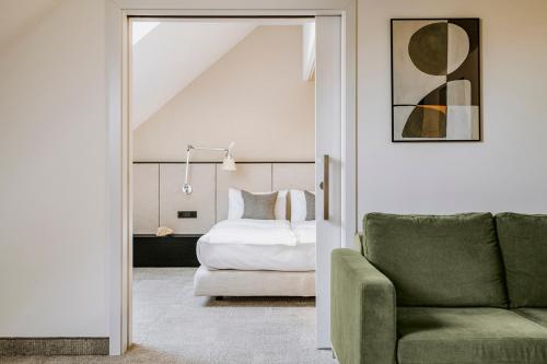 a bedroom with a bed and a couch and a chair at Poziom 511 Jura Wellness Hotel & Spa in Ogrodzieniec