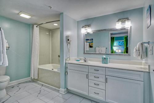 a bathroom with a sink and a tub and a toilet at Prince Resort Oceanfront 1834 at Cherry Grove Pier in Myrtle Beach