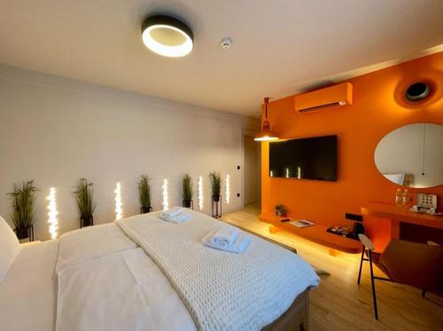 a bedroom with a large bed with an orange wall at ConnectIN Apartments in Pale