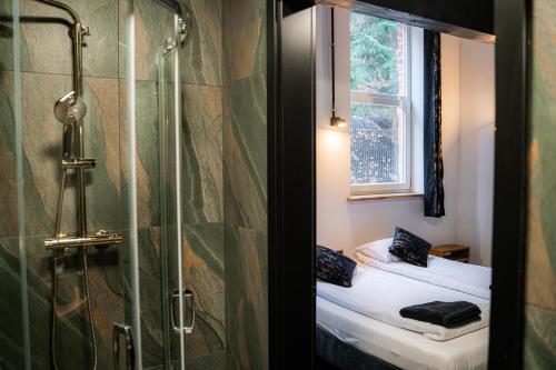 een badkamer met een douche en een raam bij Pokoje gościnne AuRoom in Złoty Stok