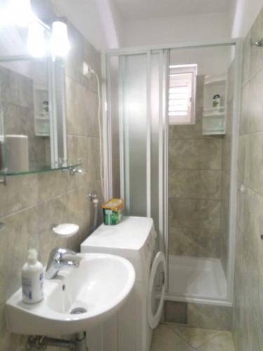 a bathroom with a sink and a shower at Sunny P in Primošten