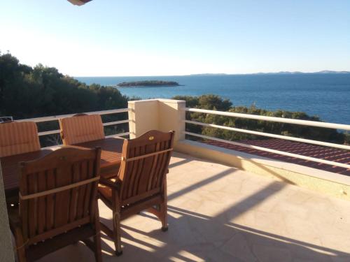 uma varanda com 2 cadeiras e vista para o oceano em Sunny P em Primošten