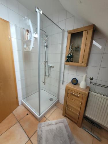 La salle de bains est pourvue d'une douche avec une porte en verre. dans l'établissement Apartment Sehring, à Oelde