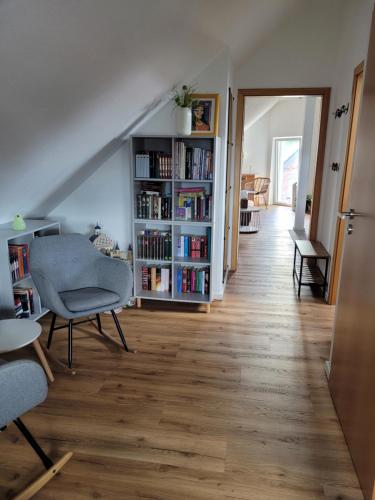 a living room with a book shelf and chairs at Apartment Sehring in Oelde