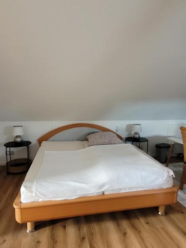 Bett in einem Zimmer mit zwei Endtischen in der Unterkunft Apartment Sehring in Oelde