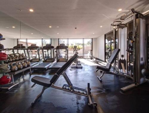 a gym with treadmills and machines in a room at Eden Condo Abbotsford in Melbourne