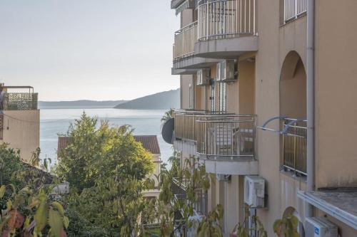un edificio de apartamentos con balcones y vistas al agua en Apartments LUX Milano, Savina,Herceg-Novi, en Herceg-Novi
