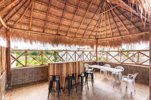una sala da pranzo con tavolo e sedie su un tetto di paglia di Casa MiAmore - Family Getaway a Cancún
