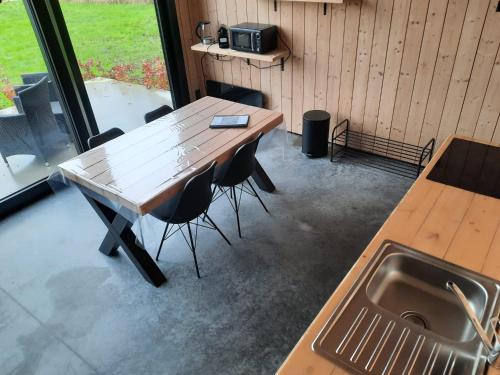 Station 25A في Duffel: طاولة وكراسي في مطبخ مع حوض