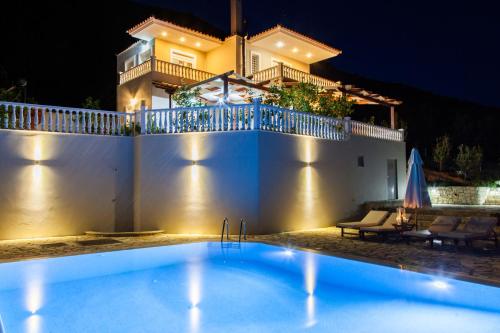 a swimming pool in front of a house at night at Dream Villa with Seaviews in Vasiliki
